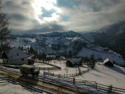 Luftaufnahme einiger Hütten im Winter mit Schnee im Nationalpark Piatra Craiului, Brasov, Rumänien - AAEF08430