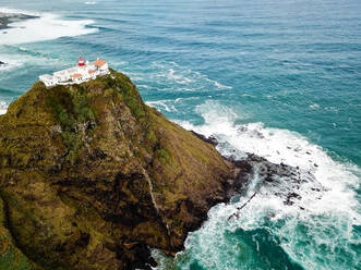Aerial view of the lighthouse of Farol da Maia on the coastline of the island of Santa Maria, Azores, Portugal. - AAEF08444
