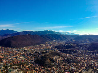 Aerial view of Brasov City with the Bucegi mountain range in the distance, Romania - AAEF08612