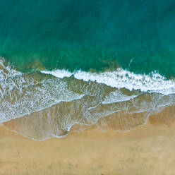 Luftaufnahme von Wellen, die an einem Strand in Fuerteventura Spanien mit lebhaften Farben brechen - AAEF08626