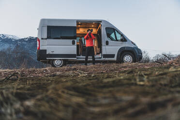 A man standing by his van taking a photograph. - ISF24043