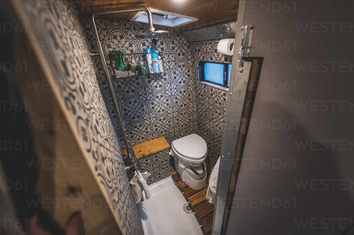 Duschbad im Wohnmobil mit gefliesten Wänden, Dusche und Toilette