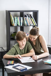 Mother homeschooling her son at home - VPIF02434