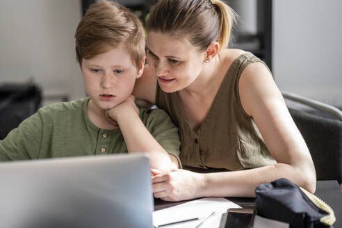 Mutter, die ihren Sohn zu Hause unterrichtet und den Laptop zu Hause benutzt - VPIF02445