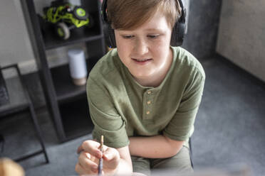 Boy painting at easel and listening to music - VPIF02449