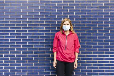 Woman with surgical mask in front of blue wall - DGOF00999