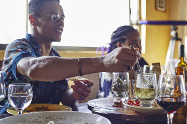 Man taking cheese while sitting at dining table during lunch - VEGF02227