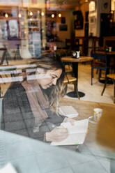 Frau arbeitet in einem Café - MGOF04259