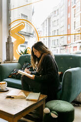 Woman working in coffee shop - MGOF04261