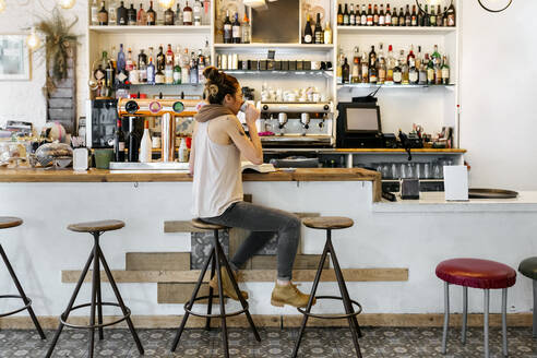 Frau trinkt Kaffee in einem Kaffeehaus - MGOF04278