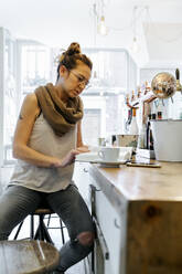 Woman reading book in coffee shop - MGOF04282