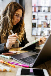 Woman working in coffee shop - MGOF04293