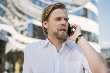 Portrait of businessman on the phone in the city - JOSEF00574