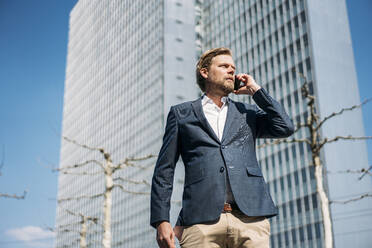 Portrait of businessman on the phone in the city - JOSEF00593