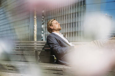 Geschäftsmann entspannt sich auf einer Bank in der Stadt - JOSEF00595