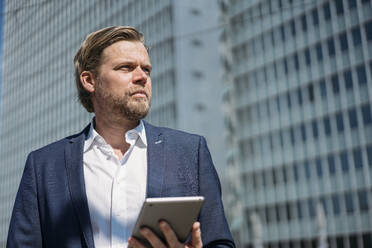 Portrait of businessman holding tablet in the city - JOSEF00598