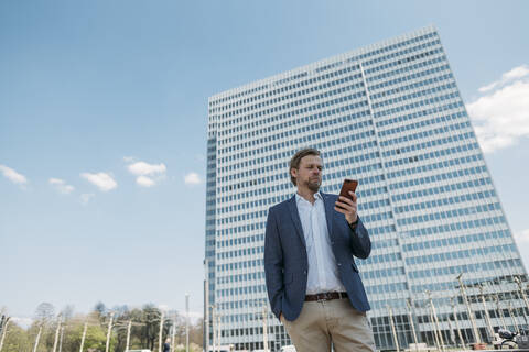 Geschäftsmann mit Smartphone in der Stadt, lizenzfreies Stockfoto