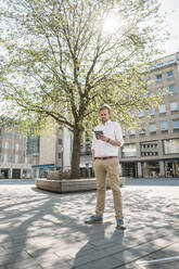 Businessman using tablet in the city - JOSEF00614