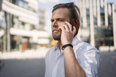 Portrait of businessman on the phone in the city - JOSEF00626