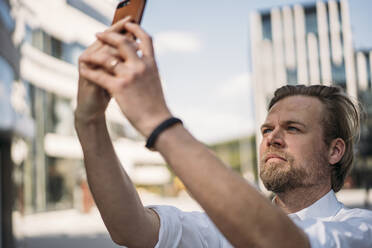 Geschäftsmann mit Smartphone in der Stadt - JOSEF00627