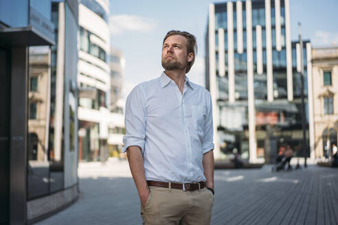 Geschäftsmann in der Stadt, der sich umschaut - JOSEF00628