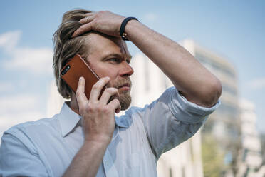 Portrait of businessman on the phone in the city - JOSEF00649