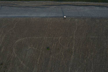 Businessman sitting on hill, drone view - MOEF02879