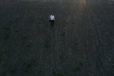 Businessman moving downhill during sunset - MOEF02890