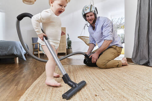 Süßes Baby Junge Reinigung Teppich mit Staubsauger von Vater im Wohnzimmer zu Hause - FSF01073