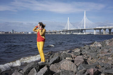 Frau an der Küste stehend und Musik hörend, Sankt Peterburg, Russland - VPIF02490