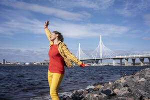 Unbeschwerte Frau an der Küste, St. Peterburg, Russland - VPIF02492