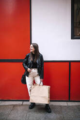 Happy young woman with shopping bags in the city - GRCF00231