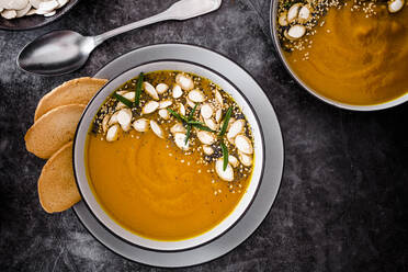 Overhead view of pumpkin soup with seeds - GIOF08174