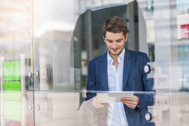 Young businessman using tablet in the city - DIGF10913