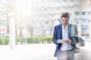 Young businessman using tablet in the city - DIGF10920