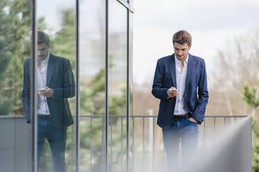 Young businessman using smartphone at an office building - DIGF10926