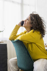 Brunette woman talking on the phone in home office - ERRF03756