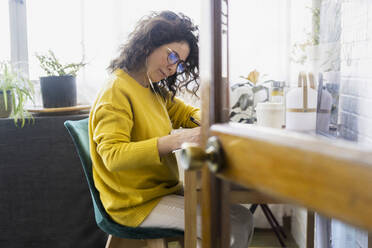 Woman working at desk in home office - ERRF03763