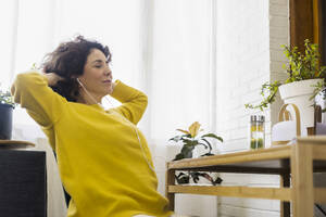 Woman having a break from working at desk in home office - ERRF03764