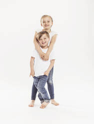 Porträt eines lächelnden Mädchens und ihres jüngeren Bruders vor einem weißen Hintergrund - SDAHF00940