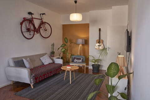 Wohnzimmer mit altem Fahrrad an der Wand, lizenzfreies Stockfoto