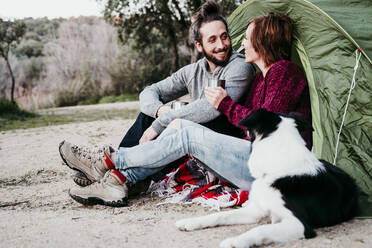 Happy couple with dog camping in the countryside - EBBF00048