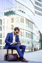 Geschäftsmann bei der Arbeit an einem digitalen Tablet im Freien, Frankfurt, Deutschland - PUF01887