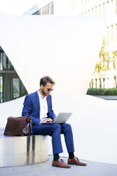 Geschäftsmann arbeitet im Freien an einem Laptop, Frankfurt, Deutschland - PUF01889