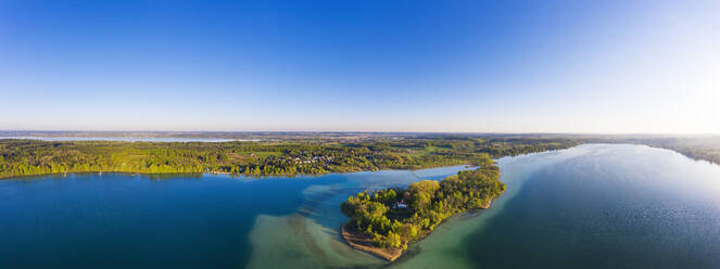 Deutschland, Bayern, Inning am Ammersee, Drohnenpanorama von klarem Himmel über dem bewaldeten Ufer der Insel Worth - SIEF09843