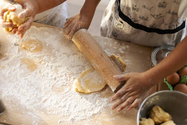 Crop view of boy rolling out dough - VABF02912