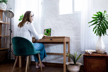 Female photographer processing pictures at home - ERRF03809