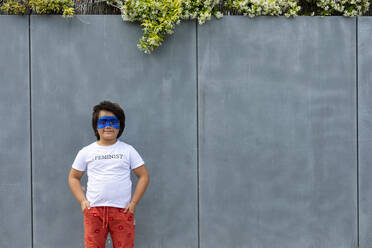 Porträt eines Jungen mit aufgemalter blauer Maske im Gesicht, der ein T-Shirt mit dem Aufdruck 'Feminist' trägt - VABF02932