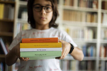 Junge hält Stapel von vier Büchern - VABF02949
