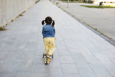 Back view of little girl with scooter on pavement - VABF02954